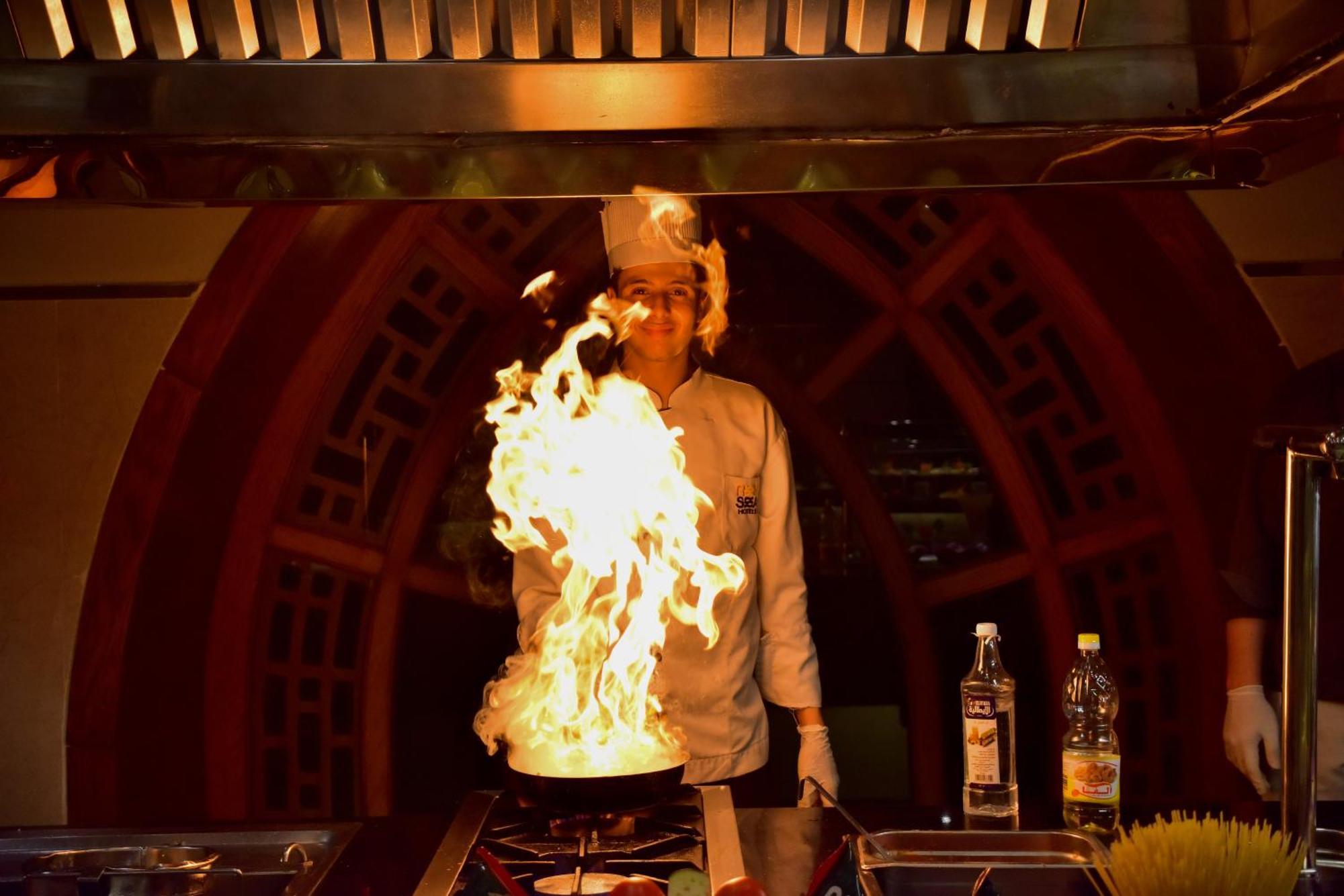 The Grand Hotel Sharm El Sheikh Exteriér fotografie A chef cooking with a flaming wok